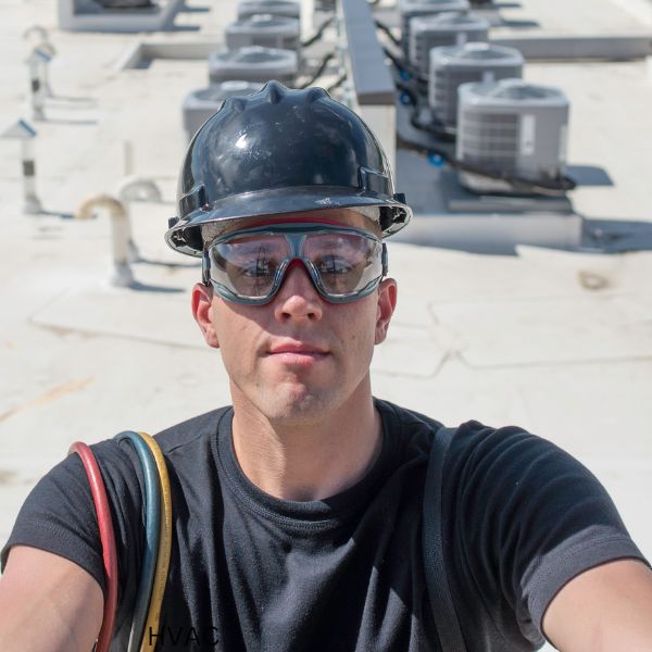 HVAC installer in safety gear on a roof